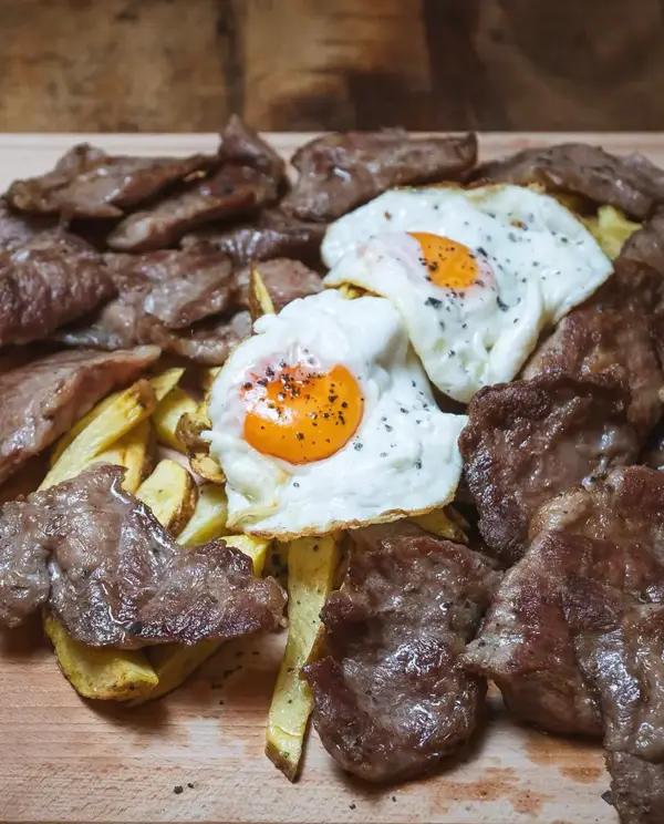 Carne a la brasa con huevos y patatas